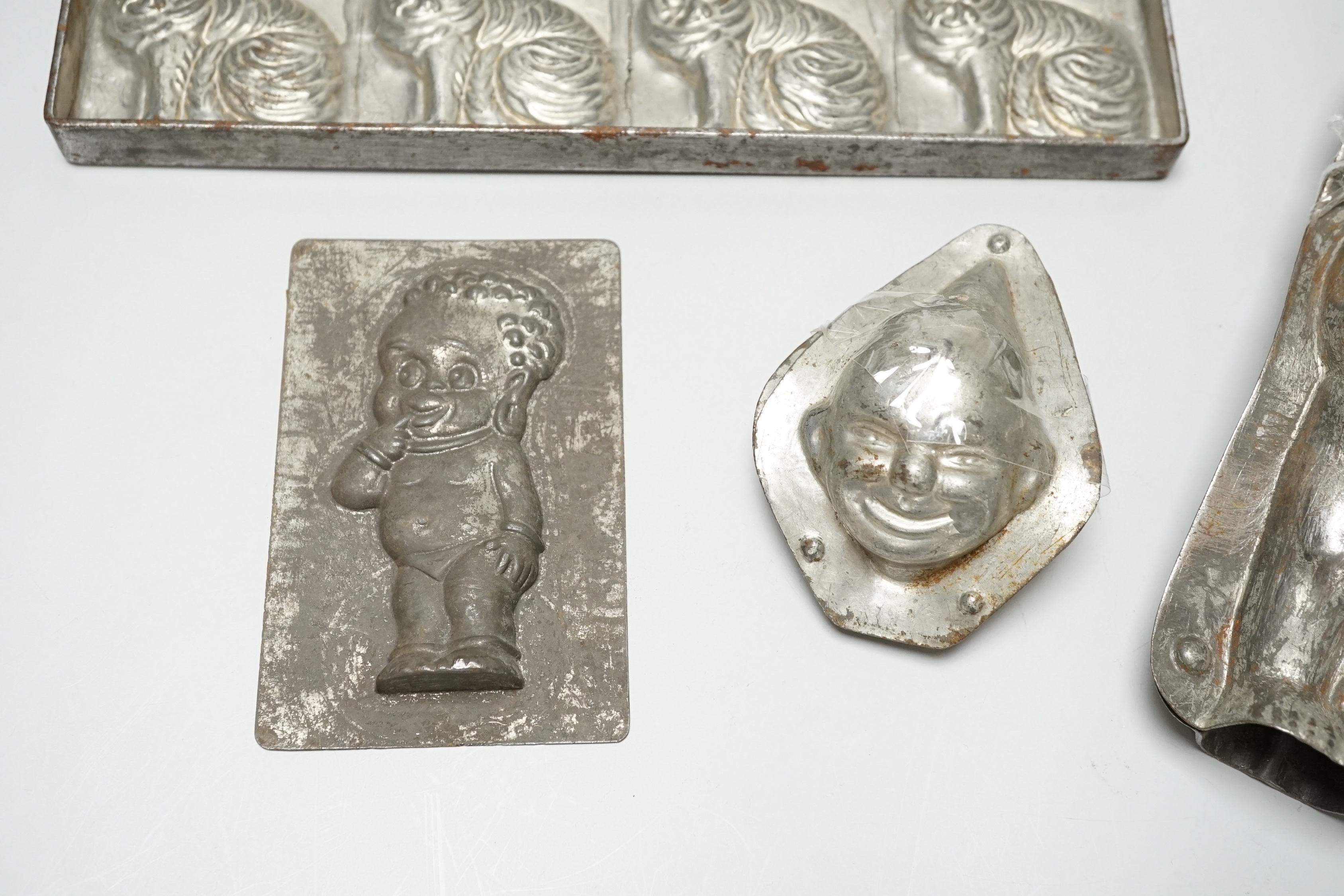 Four chocolate mould tins: a cat, a kewpie and two others